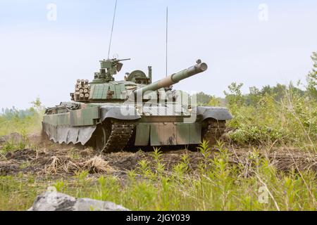 Moderner polnischer Kampfpanzer PT-91 bei Militärdemonstrationen. Eine Demonstrationsfahrt eines Militärfahrzeugs auf dem Feld. Stockfoto