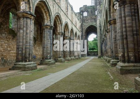 Blick auf das Kirchenschiff zum Altar der Kirkstall Abbey, einem zerstörten Zisterzienserkloster in Kirkstall, nordwestlich von Leeds, West Yorkshire, England. Stockfoto