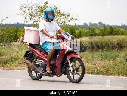 SAMUT PRAKAN, THAILAND, MAI 05 2022, Ein Mann fährt ein Motorrad mit Aufbewahrungsbox Stockfoto