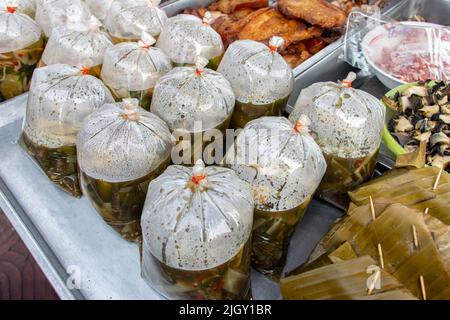 Das Angebot von Thai-Markt, Isan-Stil Pilzsuppe in einem Plastiktüten, gedünsteter Fisch in Red Curry Mousse in Blatt gewickelt und andere. Stockfoto