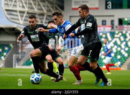 LinfieldÕs Joel Cooper (Mitte) und der New SaintsÕ Jon Routledge (rechts) und Blaine Hudson kämpfen während des UEFA Champions League-Qualifikationsrunden-Spiels im Windsor Park, Belfast, um den Ball. Bilddatum: Mittwoch, 13. Juli 2022. Stockfoto