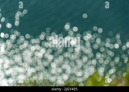 Blendung auf dem Wasser in aus dem Fokus . Abstrakter Hintergrund Stockfoto