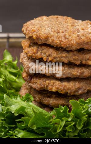 Gebratene Burger auf Salatblättern. Nahaufnahme. Draufsicht Stockfoto