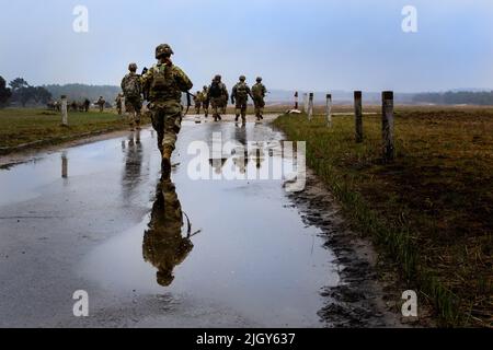 Torun, Polen. 20. April 2022. US-Soldaten, die dem Hauptquartier und dem Hauptquartier Battery, dem Bataillon 3., dem Artillerieregiment 29. (3-29. FA), dem Kampfteam der 3. Panzerbrigade und der Infanterie-Division 4. zugewiesen wurden, marschieren in die Reichweite, bevor sie ihre Waffen in Torun, Polen, am 20. April 2022 zerschießen. Der Verband 3-29. ist unter anderem dem V Corps, dem amerikanischen Vorbereitungs-Korps in Europa, zugeordnet, das mit NATO-Verbündeten und regionalen Sicherheitspartnern zusammenarbeitet, um kampfglaubwürdige Kräfte bereitzustellen und gemeinsame, bilaterale und multinationale Trainingseinheiten durchzuführen. (Bild: © U.S. Arm Stockfoto