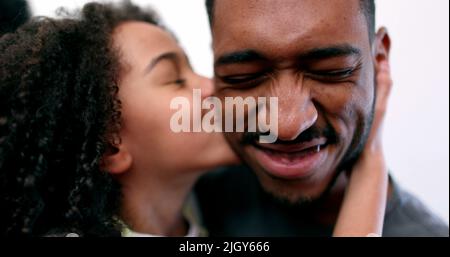 Nettes kleines Mädchen küssen älteren Bruder auf der Wange, gemischte Rasse Geschwister Stockfoto