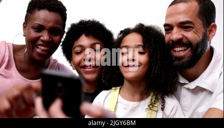 Ethnisch gemischte Rassenfamilie starrt auf das Smartphone Stockfoto