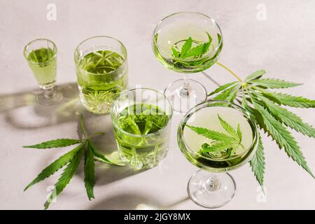 SBD Hanfgetränk in verschiedenen Gläsern, heller Betonhintergrund harter Schatten, Energy Cocktail Cannabis Stockfoto