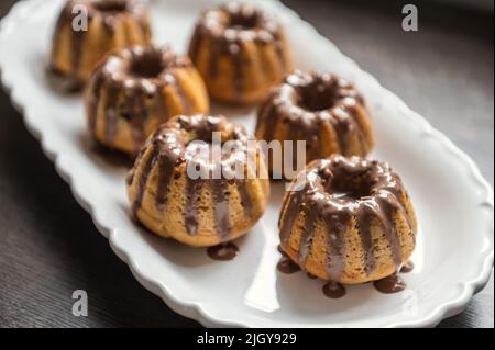 Beschichtung mit Schokolade Glasur leckere Muffins auf Geburtstagsfeier Stockfoto
