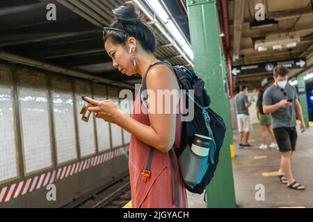 Abgelenkter U-Bahnreisender in der Bedford Avenue Station in Williamsburg in Brooklyn in New York am Samstag, den 9. Juli 2022. (© Richard B. Levine) Stockfoto