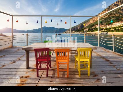 Wunderschönes Cafe am hölzernen Pier am Meer bei Sonnenuntergang im Sommer. Stockfoto