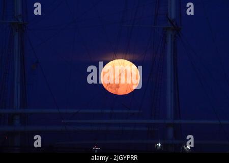 Hamburg, Deutschland. 13.. Juli 2022. Der Vollmond steigt am Abend über dem Hamburger Hafen auf. Gleichzeitig ist der Mond nahe an der Erde, weshalb er als Supermond bezeichnet wird. Kredit: Marcus Brandt/dpa/Alamy Live Nachrichten Stockfoto