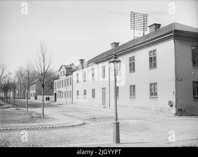 St. Olofsgatan von der Övre Slottsgatan, ehemaliges Armutshaus im Pistolen-Block, Fjärdingen, Uppsalsa 1901 - 1902. Gebäude auf der St. Olofsgatan (ehemals Järnbrogatan) mit Telefonmast auf dem Dach. Im Vordergrund Gaslaterne. Die Kreuzung S: t Olofsgatan und Övre Slottsgatan. Das Gebäude war, als die Arbeit des Stadtbildes 1964 geschrieben wurde, ein zweistöckiges Wohnhaus aus Stein. Expedition des Pastors und Wohnsitz des Pastors der Kirche. Errichtet als Armenhaus für die Stadt Uppsal nach Zeichnungen von 1832 von C. G. Blom Carlsson. Später epidemische Krankenhaus. Eingelöst gemäß Zeichnungen f Stockfoto