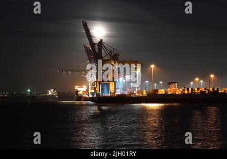 Hamburg, Deutschland. 13.. Juli 2022. Der Vollmond steigt am Abend über dem Hamburger Hafen auf. Gleichzeitig ist der Mond nahe an der Erde, weshalb er größer als gewöhnlich erscheint und als Supermond bezeichnet wird. Kredit: Marcus Brandt/dpa/Alamy Live Nachrichten Stockfoto