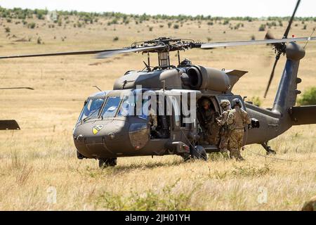 BABADAG TRAININGSGEBIET, Rumänien-- Luftwaffe wird dem Vereinigten Königreich zugewiesen 140. Expeditionary Air Wing beladen einen UH-60 Black Hawk während des Trainings zur Personalerholung mit 3-227 AHB, 12. Juli 2022. Regelmäßige Interoperabilitätsschulungen mit NATO-Partnern und Verbündeten schaffen Vertrauen und Bereitschaft, wodurch die Fähigkeit zur Abschreckung und Verteidigung erhöht wird. (USA Armeefoto von Capt. Taylor Criswell) Stockfoto