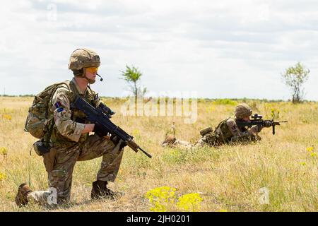 BABADAG TRAININGSGEBIET, Rumänien-- Luftwaffe, die dem Vereinigten Königreich zugewiesen wurde 140. Expeditionary Air Wing, die während der Schulung zur Personalrückgewinnung mit 3-227 AHB die Sicherheit des Bereichs durchführen, 12. Juli 2022. Regelmäßige Interoperabilitätsschulungen mit NATO-Partnern und Verbündeten schaffen Vertrauen und Bereitschaft, wodurch die Fähigkeit zur Abschreckung und Verteidigung erhöht wird. (USA Armeefoto von Capt. Taylor Criswell) Stockfoto