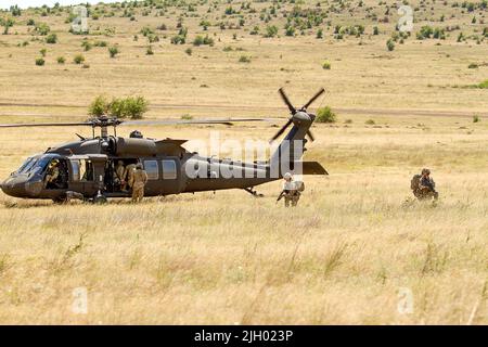 BABADAG TRAININGSGEBIET, Rumänien-- Luftwaffe mit dem U.K. 140. Expeditionary Air Wing beladen einen UH-60 Black Hawk während des Trainings zur Personalerholung mit 3-227 AHB, 12. Juli 2022. Regelmäßige Interoperabilitätsschulungen mit NATO-Partnern und Verbündeten schaffen Vertrauen und Bereitschaft, wodurch die Fähigkeit zur Abschreckung und Verteidigung erhöht wird. (USA Armeefoto von Capt. Taylor Criswell) Stockfoto