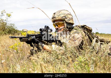 BABADAG TRAININGSGEBIET, Rumänien-- an Airman with the U.K. 140. Expeditionary Air Wing provides area Security during personnel Recovery Training with 3-227 AHB, 12. Juli 2022. Regelmäßige Interoperabilitätsschulungen mit NATO-Partnern und Verbündeten schaffen Vertrauen und Bereitschaft, wodurch die Fähigkeit zur Abschreckung und Verteidigung erhöht wird. (USA Armeefoto von Capt. Taylor Criswell) Stockfoto