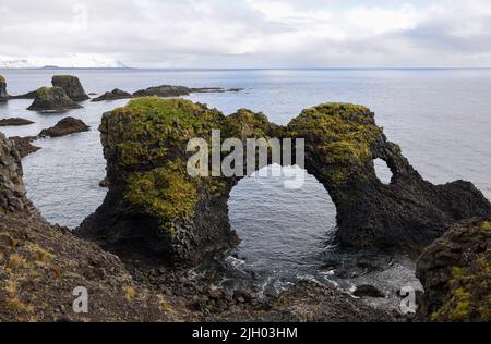 Die berühmteste Felsformation in der Gegend von Arnarstapi ist Gatklettur, oder Hole Rock. Der Name ist offensichtlich, da es ein riesiges Loch durch den Felsen gibt. Stockfoto