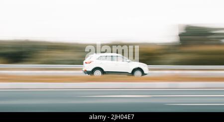 Eine seitliche Schwenkaufnahme eines weißen Autos von Hyundai Creta auf einer Straße Stockfoto