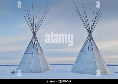 Zwei Tipis im Winter in der nördlichen indigenen Gemeinde Deline, Northwest Territories, Kanada. Stockfoto