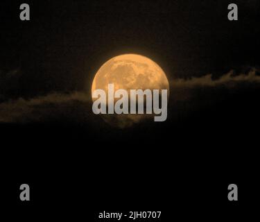 Glasgow, Schottland, Großbritannien, Juli 13. 2022. Wetter in Großbritannien: Super Buck Moon kämpft nach einem wechselhaften Tag, der regnete, durch einen bewölkten Himmel über den Lichtern des Südens der Stadt. Credit Gerard Ferry/Alamy Live News Stockfoto