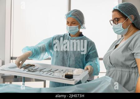 Arzt und Krankenschwester Untersuchungstisch mit chirurgischen Instrumenten vor der Operation Stockfoto