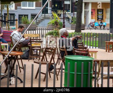 Männer sitzen in einem Café im Freien in Amsterdam Stockfoto