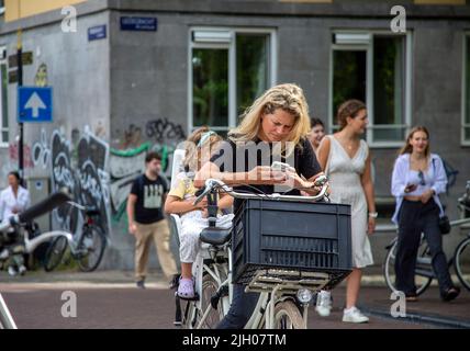 Mutter und Tochter auf einem Tandem-Fahrrad auf einem Amsterdamer Radweg Stockfoto