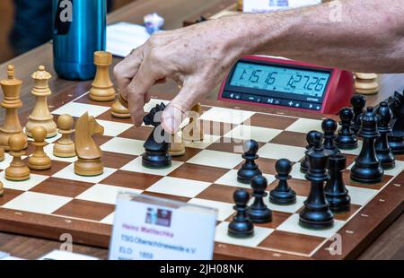 Berlin, Deutschland. 13.. Juli 2022. Eine Hand bewegt eine Figur während der Werner Ott Open des Kreuzberger Sommers im Berliner Kreuzberger Schachclub über das Schachbrett. Der Internationale Tag des Schachs wird am 20.07.2022 stattfinden. Quelle: Andreas Gora/dpa/Alamy Live News Stockfoto