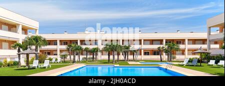 Ein moderner Wohnkomplex mit einem breiten blauen Swimmingpool Stockfoto