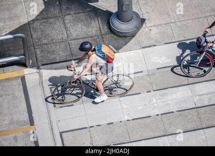 Eine Gruppe von Amateurradfahrern fährt auf dem Bürgersteig der Stadt Fahrrad und bevorzugt einen aktiven, gesunden Lebensstil, indem sie alternativ Radfahren und Radfahren verwenden Stockfoto