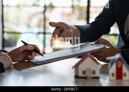 Immobilienkonzept. Geschäftsmann, der auf den Vertragsvertrag verweist. Stockfoto