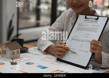 Immobilienkonzept. Geschäftsmann, der auf den Vertragsvertrag verweist. Stockfoto