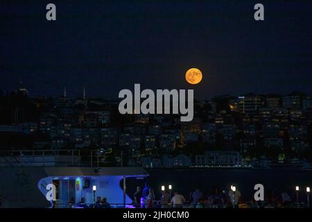 Istanbul, Türkei. 13.. Juli 2022. Ein Boot wurde durch den Bosporus in Istanbul mit dem Super-Vollmond gesehen, wo der Mond der Erde am nächsten ist, größer und heller als normal. Kredit: SOPA Images Limited/Alamy Live Nachrichten Stockfoto