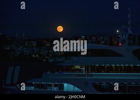 Istanbul, Türkei. 13.. Juli 2022. Ein Boot wurde durch den Bosporus in Istanbul mit dem Super-Vollmond gesehen, wo der Mond der Erde am nächsten ist, größer und heller als normal. (Foto von Onur Dogman/SOPA Images/Sipa USA) Quelle: SIPA USA/Alamy Live News Stockfoto