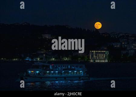 Istanbul, Türkei. 13.. Juli 2022. Ein Boot wurde durch den Bosporus in Istanbul mit dem Super-Vollmond gesehen, wo der Mond der Erde am nächsten ist, größer und heller als normal. (Foto von Onur Dogman/SOPA Images/Sipa USA) Quelle: SIPA USA/Alamy Live News Stockfoto