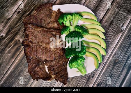 Keto-Diät basiert auf Rindersteak, Brokkoli und Avocado Stockfoto