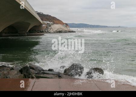 14. Juli 2022, San Diego, CA, USA: Die Korallen, Bäume, Felsen, Strand, Wellen, Orange Wolken, Ozean und hohe Brandung während des glitzernden Sommeruntergangs in La Jolla, Kalifornien, am Mittwoch, den 13.. Juli 2022 (Bildnachweis: © Rishi Deka/ZUMA Press Wire) Stockfoto