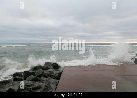 14. Juli 2022, San Diego, CA, USA: Die Korallen, Bäume, Felsen, Strand, Wellen, Orange Wolken, Ozean und hohe Brandung während des glitzernden Sommeruntergangs in La Jolla, Kalifornien, am Mittwoch, den 13.. Juli 2022 (Bildnachweis: © Rishi Deka/ZUMA Press Wire) Stockfoto