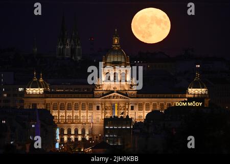 Prag, Tschechische Republik. 13.. Juli 2022. Supermoon, beobachtet am 13. Juli 2022 in Prag, Tschechische Republik. Im Vordergrund befindet sich das Gebäude des Nationalmuseums. Quelle: Ondrej Deml/CTK Photo/Alamy Live News Stockfoto