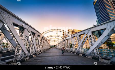 Die Anderson Bridge ist eine Fußgängerbrücke, die 1910 erbaut wurde und das Fullerton Hotel im Blick hat. Stockfoto