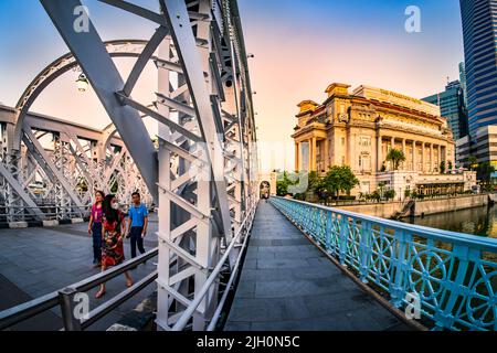 Die Anderson Bridge ist eine Fußgängerbrücke, die 1910 erbaut wurde und das Fullerton Hotel im Blick hat. Stockfoto
