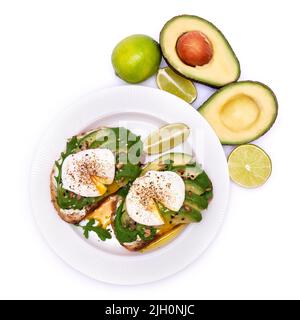 Frisch zubereitetes pochiertes Ei und Avocado-Toast isoliert auf weißem Hintergrund Stockfoto