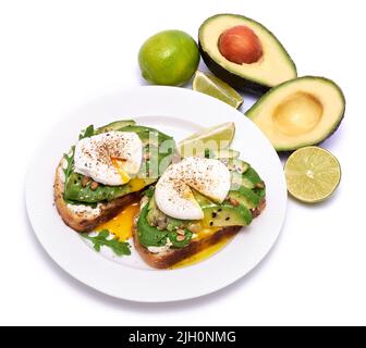 Frisch zubereitetes pochiertes Ei und Avocado-Toast isoliert auf weißem Hintergrund Stockfoto