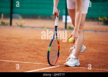 Weibliche Tennisspieler Beine im Tennis Schuhe stehen auf einem Sandplatz in der Nähe. Stockfoto