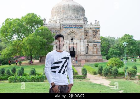 Ein Mann, der vor dem indischen Denkmal steht, das als Sheesh gumbad bekannt ist und für Fotos posiert. Stockfoto