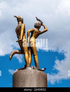 Bronzeskulptur „Tanzendes Paar“ des Bildhauers Joachim Schmettau mitten auf dem Hermannplatz, Neukölln, Berlin, Deutschland. Lieblingsplatz für Pigeo Stockfoto