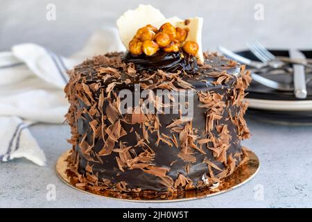 Kuchen zum Feiern. Geburtstagskuchen mit Krokus auf steinernem Hintergrund. Mit Schokolade überzogene Kuchen. Nahaufnahme Stockfoto