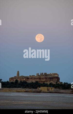 Siwa Oasis, Ägypten, 14. Juli 2022. Der Vollmond des Juli untergeht über dem orakel von Zeus - Ammon. Quelle: Dimitris Aspiotis/Alamy Live News Stockfoto