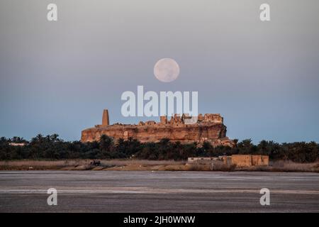 Siwa Oasis, Ägypten, 14. Juli 2022. Der Vollmond des Juli untergeht über dem orakel von Zeus - Ammon. Quelle: Dimitris Aspiotis/Alamy Live News Stockfoto